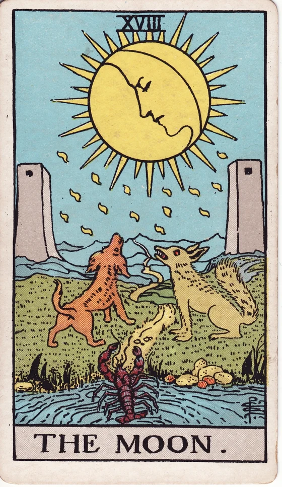 The Moon tarot card from the Rider–Waite–Smith deck: a full moon with a face over a path between two towers, a dog and a wolf howling, a crayfish emerging from a pool.